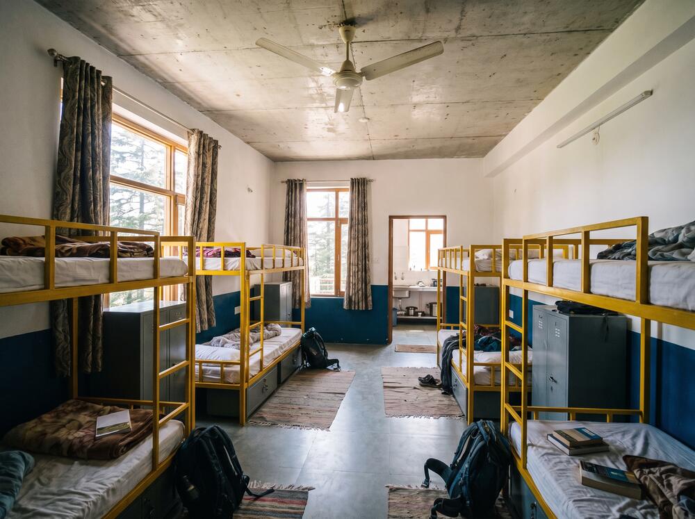 The mixed dorm, four yellow steel bunks under south-facing windows