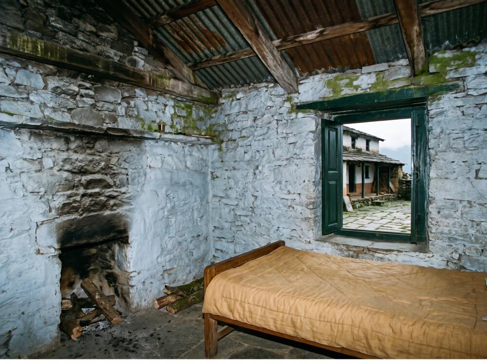 The converted byre across the yard, with thick stone walls, a fireplace and a low bed